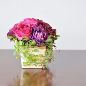 Detalle recipiente cristal con rosas de diferentes tonos